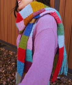 a woman wearing a multicolored scarf and hat