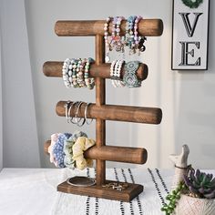 a wooden jewelry stand with bracelets and rings on it