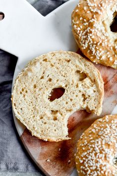 three bagels sitting on top of a cutting board