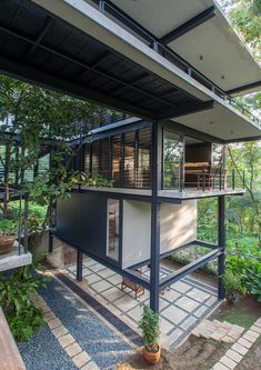 a modern house in the woods surrounded by greenery