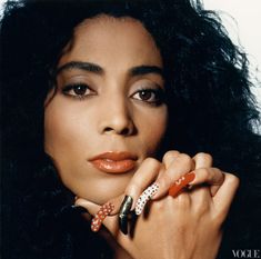 a close up of a person with long hair holding a ring on her finger and looking at the camera