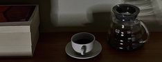 a coffee cup and saucer sitting on a table next to a stack of books