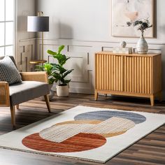 a living room area with a rug, chair and potted plant on the floor