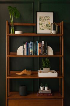 a shelf with books and plants on it