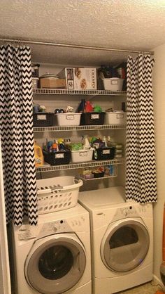 a washer and dryer in a small room with black and white drapes