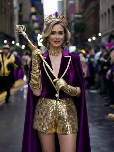 a woman dressed in gold and purple is holding a wand while walking down the street