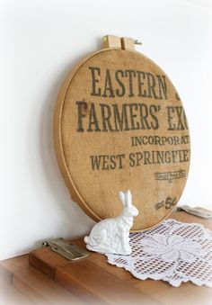 an old fashioned wooden sign with a white rabbit figurine next to it on a shelf