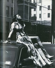 a woman sitting on the hood of a car