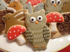 decorated cookies with owls and mushrooms on a plate