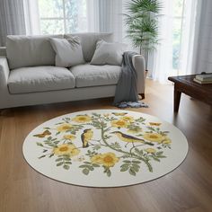 a living room with a white couch and yellow flowers on the rug in front of it