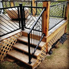 a set of stairs made out of wood and wrought iron handrails on a deck