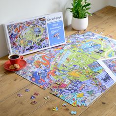 a puzzle on the floor next to a cup of coffee and a potted plant