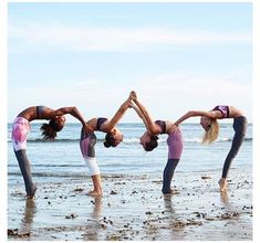 four women doing yoga poses on the beach