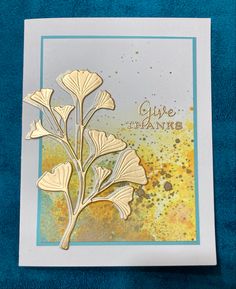 a close up of a greeting card on a blue background with watercolor paint and gold foil