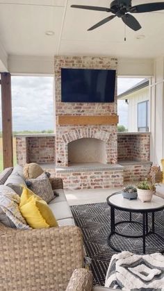 an outdoor living area with wicker furniture and a flat screen tv mounted on the wall