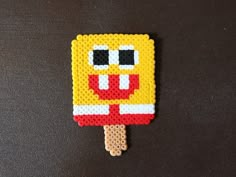 an ice lolly popsicle made out of perler beads on a black surface