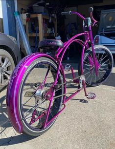 a purple bicycle parked in front of a garage