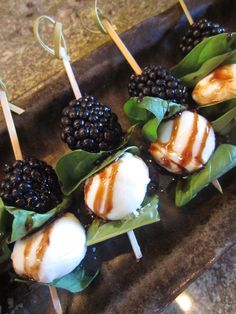 small appetizers with blackberries and greens on sticks