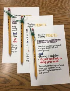 two pencils sitting next to each other on top of a wooden table with writing