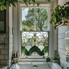 a bath tub sitting under a window next to a sink