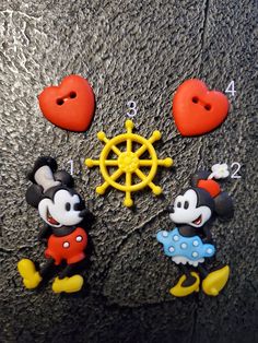 mickey and minnie mouse magnets are on the floor next to a steering wheel with hearts