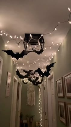 some lights are hanging from the ceiling in a hallway with bats on it and other decorations