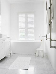 a white bathroom with a tub, toilet and sink