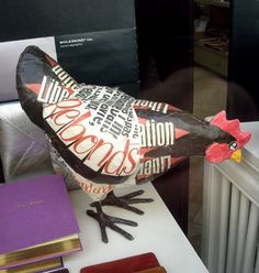 a bird made out of newspaper sitting on top of a radiator