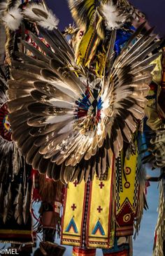 an image of some people that are performing in the air with feathers on their head