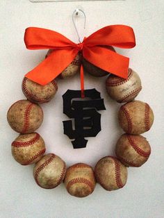 a wreath made out of baseballs with the number 5 on it and an orange bow