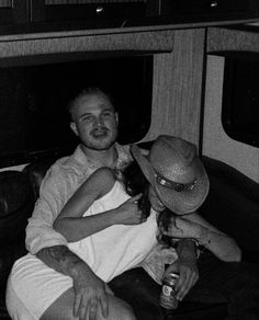 a man and woman sitting on top of a couch next to each other