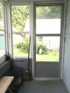 a porch with a wooden bench and large window