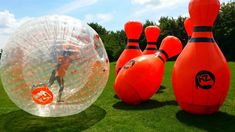 an inflatable ball and two bowling balls on the grass