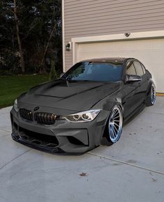 a grey car parked in front of a garage