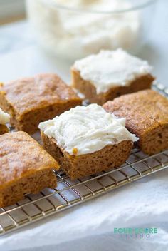 four pieces of cake on a cooling rack with cream cheese frosting in the middle