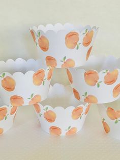 paper cups with peaches painted on them are lined up in rows and placed on top of each other