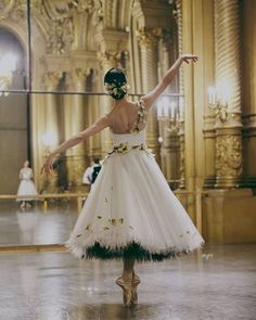 a woman in a white dress is dancing