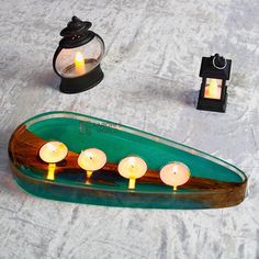 candles are lit on a green boat shaped candle holder