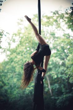 two women doing aerial acrobatics in the woods