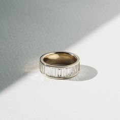 a gold and white diamond ring on a white surface