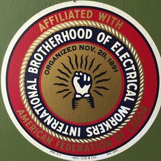 an emblem on the side of a green wall that says, affiliated with neighborhood of electricians