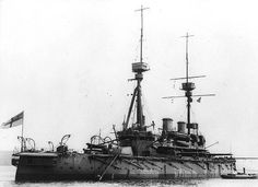 an old photo of a ship in the water with two flags on it's mast