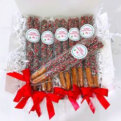 a box filled with assorted candy canes and candies next to red bows