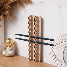 three toothbrushes are hanging on the wall next to a gold skull and mirror