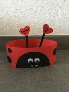 a ladybug paper crown with two hearts on it