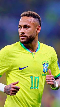 the soccer player is running with his hand on his hip and looking at the camera