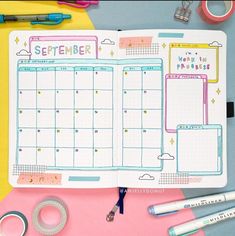 an open planner on top of a pink table