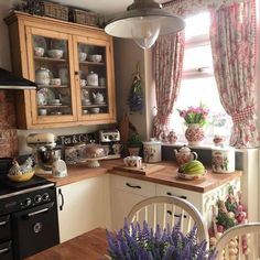 a kitchen filled with lots of counter top space and wooden cabinets next to a window