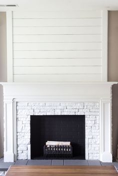 a living room with a fire place and white painted brick fireplace mantel in the center