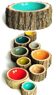 several different colored bowls sitting on top of each other in front of a tree stump